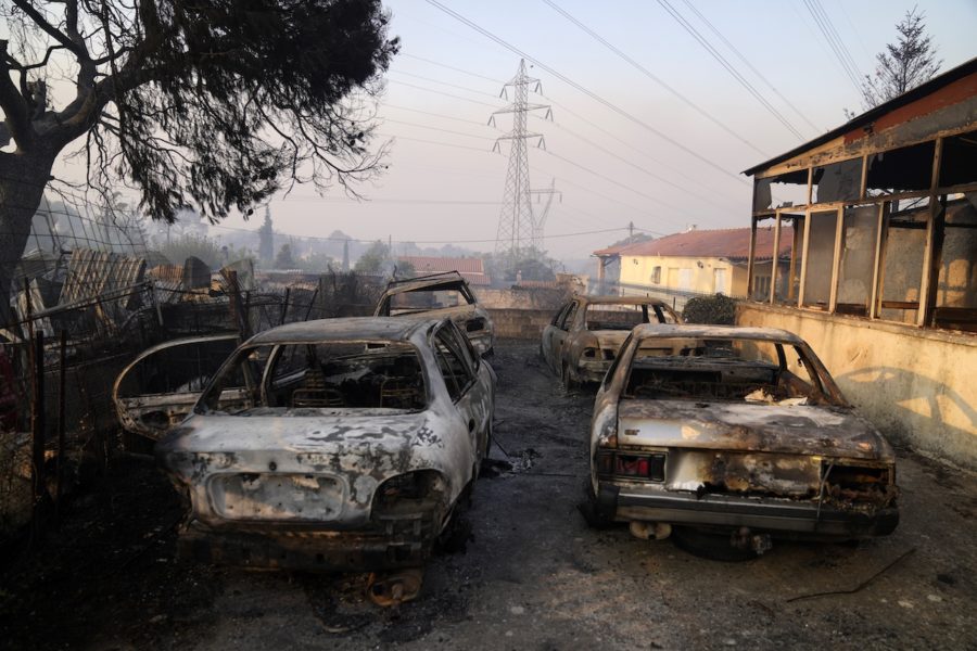 Brända bilar i Atenförorten Varybóbi, där en stor skogsbrand rasar på berget Parnithas sluttningar.