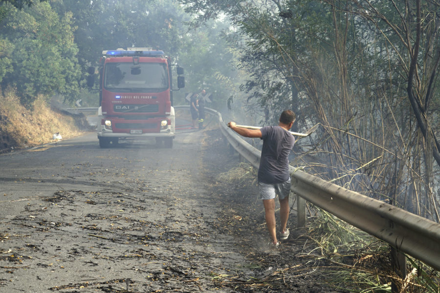 En frivillig brandbekämpare bistår i arbetet mot lågorna i Fuscaldo i regionen Kalabrien i onsdags.