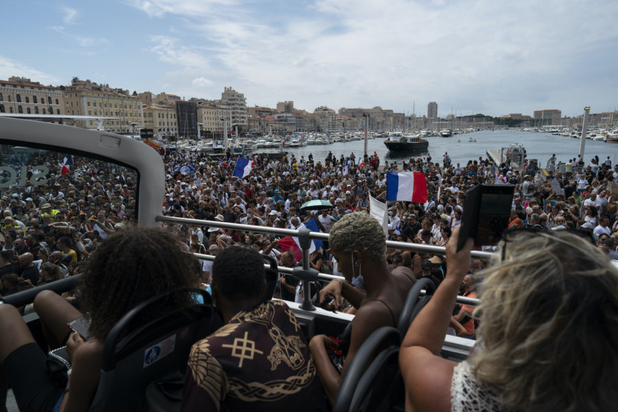 Turister bevittnar protester mot de utvidgade reglerna om covidpass i Marseille i lördags.