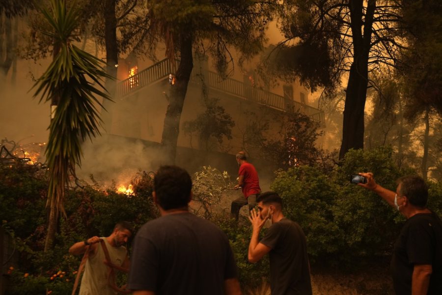 Desperata människor försöker släcka elden som härjar i byn Pfeki, på Greklands näst största ö, Evia, 189 kilometer från Aten, den.