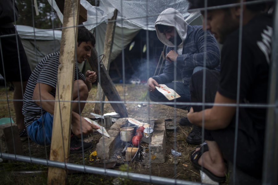 Migranter lagar mat i ett nybyggt flyktingläger 38 kilometer söder om Vilnius i Litauen.