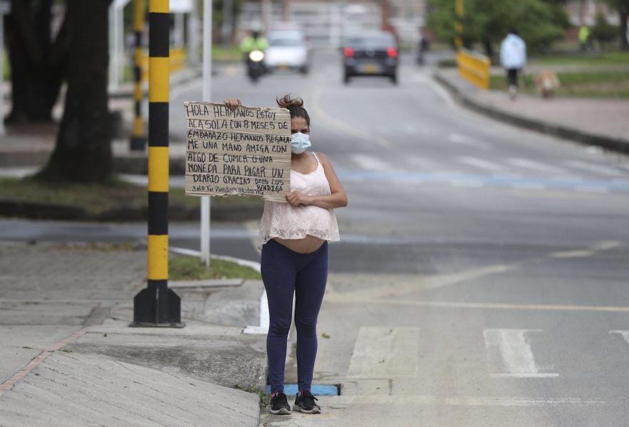 Veronica Hernandez, 20, från Venezuela är gravid i åttonde månaden och tigger vid ett övergångsställe i Bogota, Colombia.