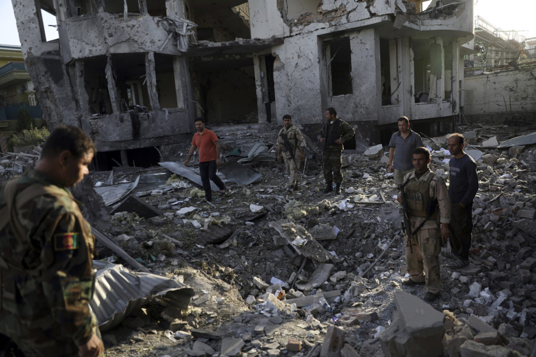 Säkerhetspersonal inspekterar en byggnad som skadats i en attack nära Kabuls diplomatkvarter.