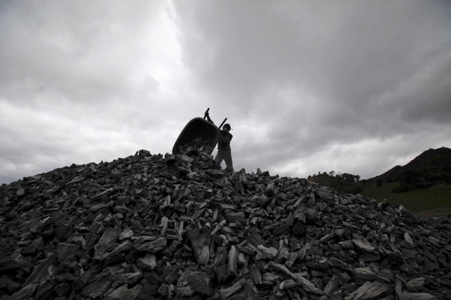 En arbetare på en hög av kol vid en kolgruva.