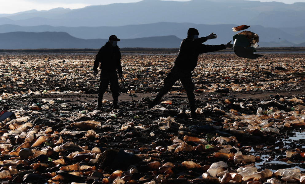 Poliser i Bolivia rensar skräp från en flod som översvämmats av plastavfall.