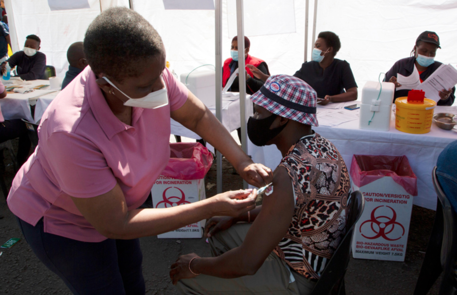 En sköterska delar ut en dos covidvaccin i Soweto i Sydafrika.