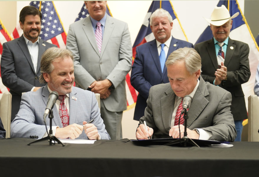 Texas guvernör Greg Abbott (till höger) signerar den nya vallagen.