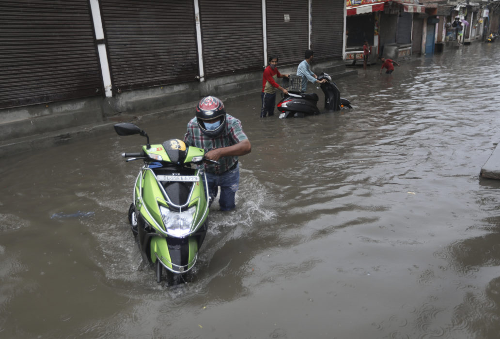 Delhibor kämpar sig fram genom den indiska huvudstadens vattenfyllda gator.