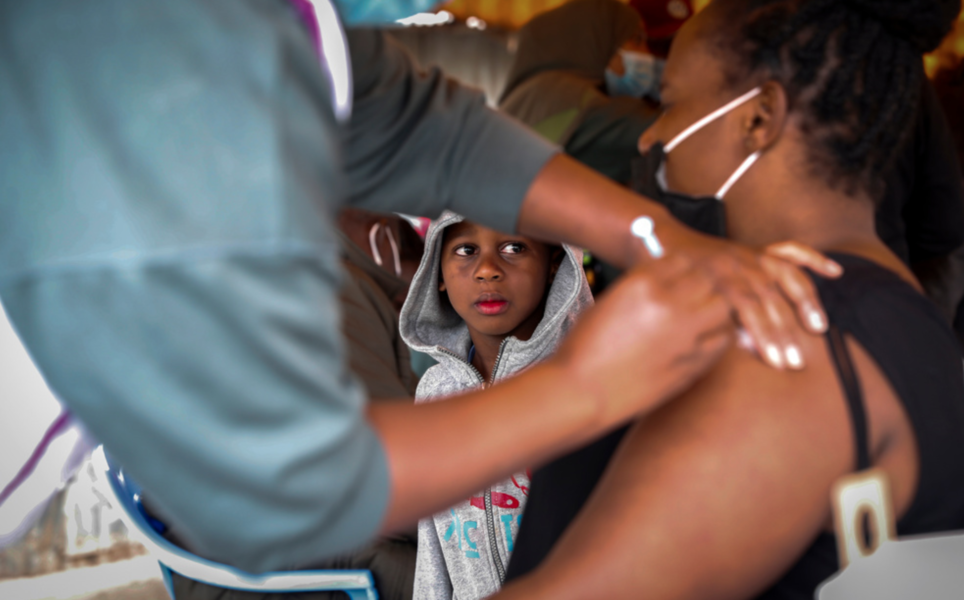 En kvinna i Kenya får en dos covidvaccin från Astra Zeneca som donerats av Storbritannien.