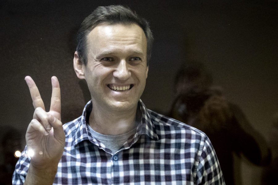 Oppositionspolitikern Aleksej Navalnyj gör segertecknet under en av årets rättegångar mot honom i Ryssland.