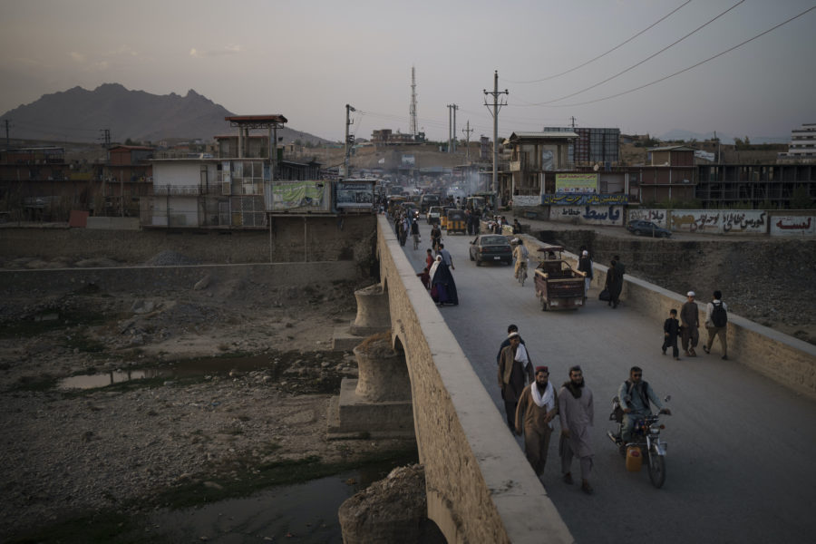 Människor går på en bro som leder över en flod i Kabul.