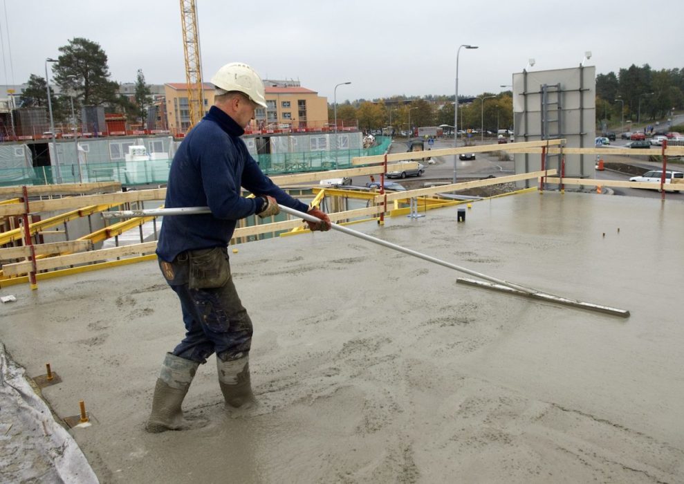 Betongarbetare gjuter på byggarbetsplats.