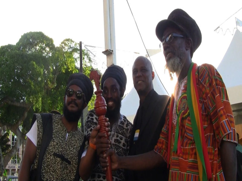 Ras Bongo Wisely Tafari (längst till höger) håller upp den stafettsymbol som används av samarbetsorganisationen Caricoms länder i arbetet för att kräva ersättning för slavhandeln.