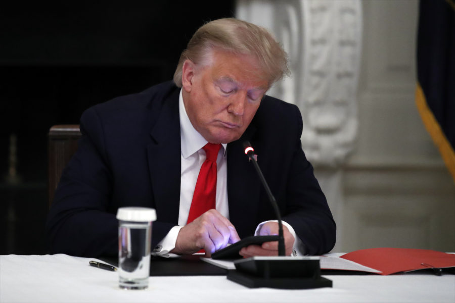 Dåvarande presidenten Donald Trump med sin telefon under ett möte i Vita huset i juni 2020.