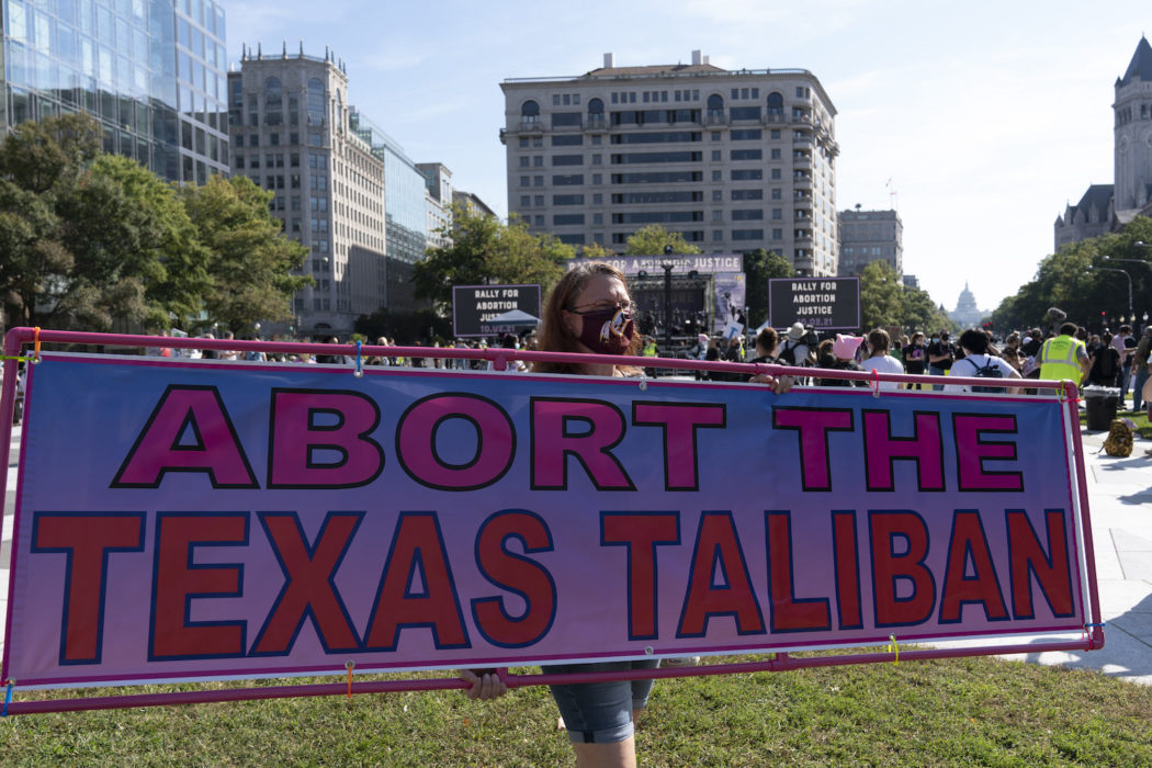 En demonstrant i Washington DC håller upp en skylt med orden "abortera Texastalibanerna".