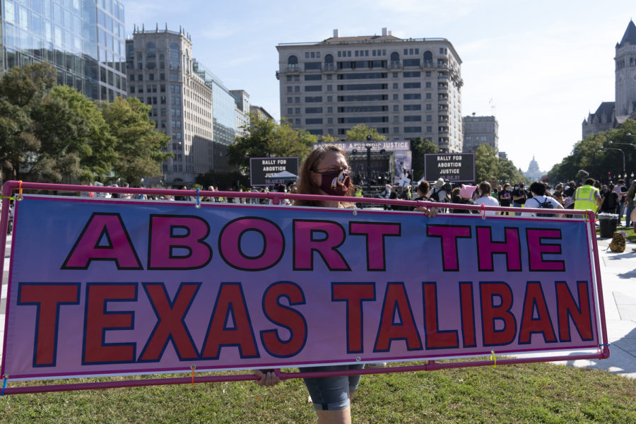 En demonstrant i Washington DC håller upp en skylt med orden "abortera Texastalibanerna".