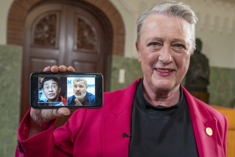 Berit Reiss-Andersen, ordförande i Nobelkommittén, visar en bild på en mobiltelefon av årets fredsprisvinnare, journalisterna Maria Ressa och Dmitrij Muratov, på Nobelinstitutet i Oslo.