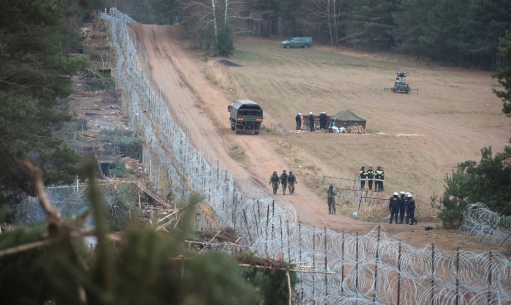 På vänster sida syns nyligen övergivna migrantläger vid Kuznice, på gränsen mellan Belarus och Polen.