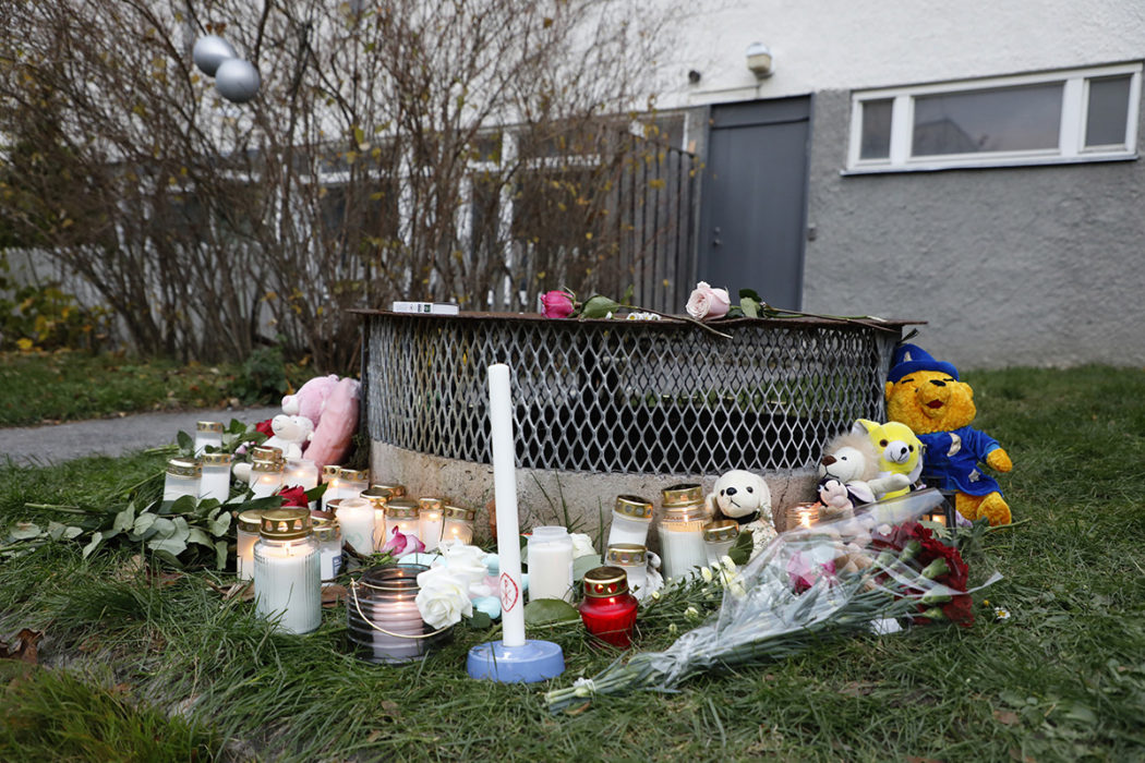 Gosedjur, blommor och ljus har lagts ner vid den plats där två barn hittades med livshotande skador utanför ett bostadshus i Hässelby i söndags kväll.