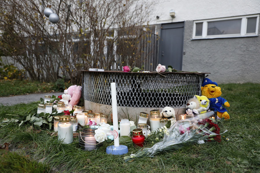 Gosedjur, blommor och ljus har lagts ner vid den plats där två barn hittades med livshotande skador utanför ett bostadshus i Hässelby i söndags kväll.