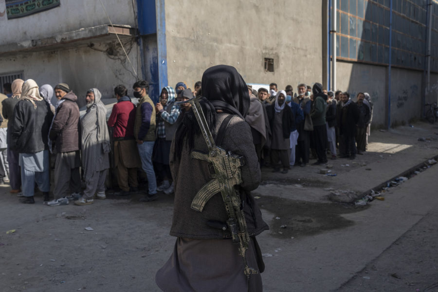 Afghanska medborgare köar för att få pengar av FN:s livsmedelsprogram.
