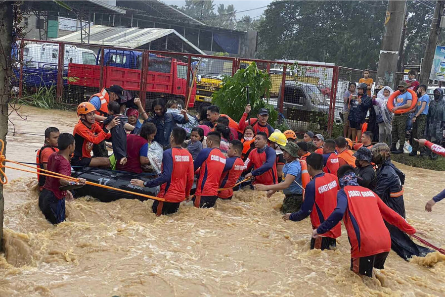Räddningsarbetare hjälper hjälper till med evakuering under höga vattenflöden orsakade av tyfonen Rai.