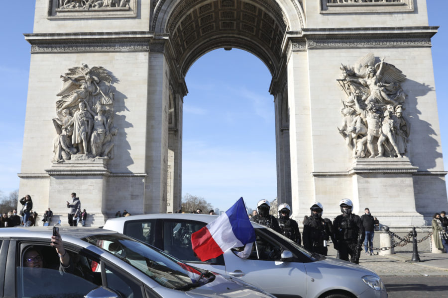 Polis och bilburna demonstranter vid Triumfbågen i Paris.