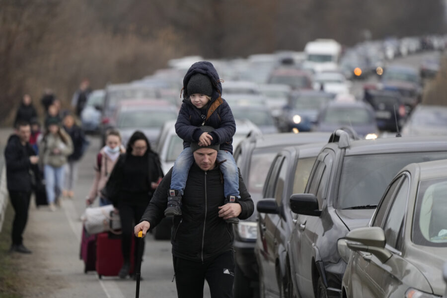 Ukrainska flyktingar vandrar förbi bilköerna vid gränsen till Moldavien vid Mayaky-Udobne-gränsövergången.