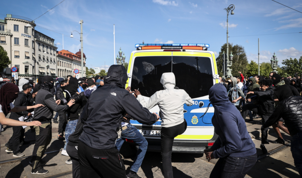 Maskerade personer attackerar en polisbil i samband med en demonstration för Black Lives Matter i Göteborg 2020.