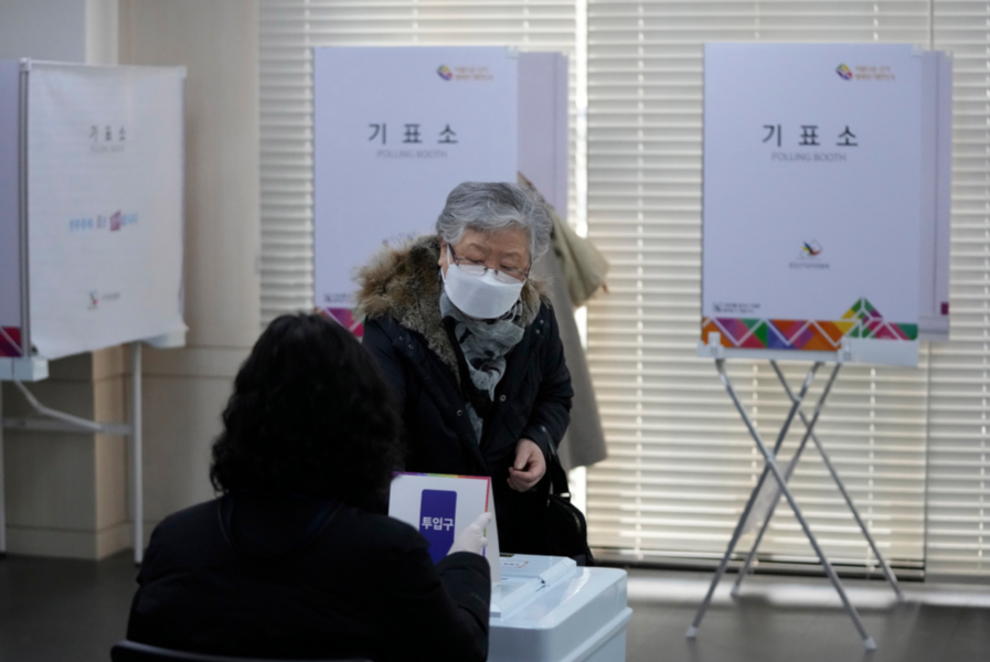 En väljare lägger sin röst i valurnan i en vallokal i Sydkoreas huvudstad Seoul på onsdagen.