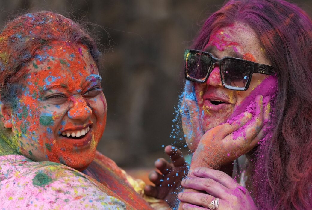 Två kvinnor i Mumbai firar Holi.
