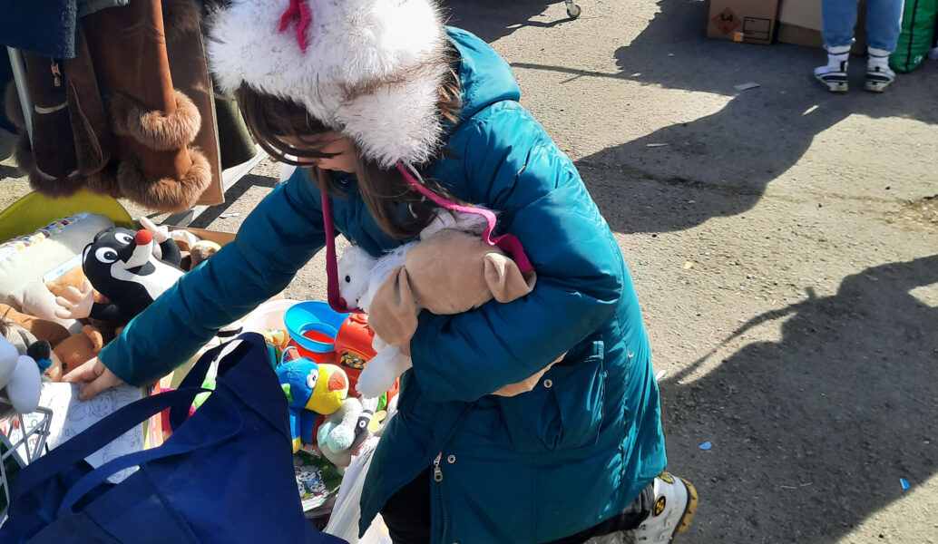 En flicka som flytt från Ukraina letar bland leksaker som har donerats av frivilliga.