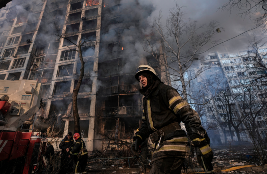 Räddningspersonal på plats efter det att ett bostadshus i Kiev bombats.