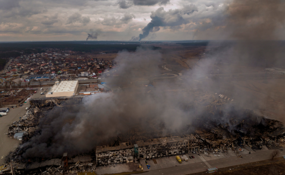 En fabrik i Irpin i utkanterna av Kiev brinner efter att ha beskjutits av rysk artillerield under söndagen.