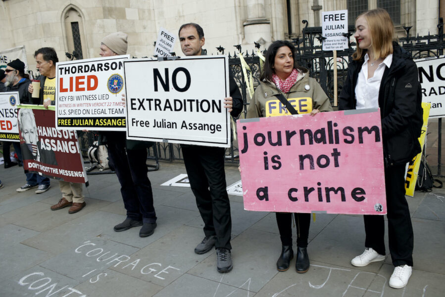 Människor utanför den brittiska Högsta domstolen i London i oktober 2021 som reagerar mot en eventuell utlämning av Julian Assange till USA.