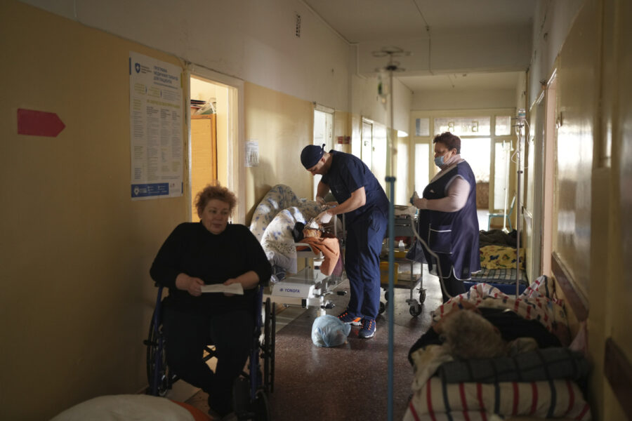 En vårdanställd tar hand om en skadad man på ett sjukhus i Mariupol, en av de ukrainska städer som drabbats hårt av kriget.