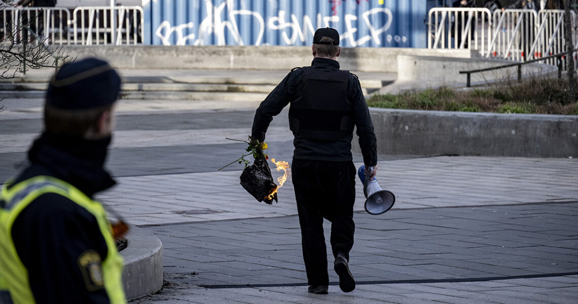 Den danske rasisten Rasmus Paludan går iväg med sin brinnande koran och sin megafon.