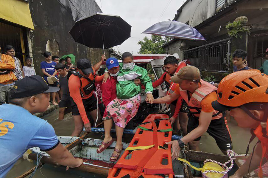 Räddningspersonal i färd med att evakuera en kvinna i Abuyog i provinsen Leyton.