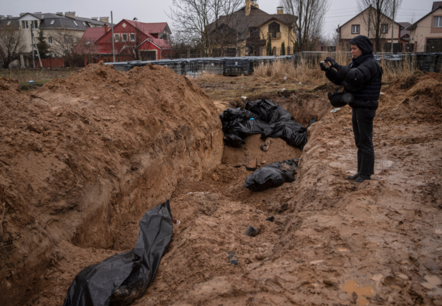 En journalist tar på söndagen den 3 april en bild på en massgrav i Butja, utanför Kiev.