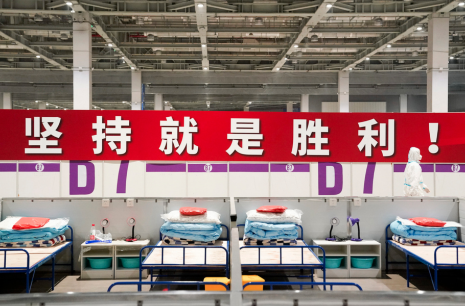 "Uthållighet innebär seger!" lyder en banderoll på på ett provisoriskt sjukhus och karantänsfacilitet i Shanghai, som har stängt ned för att stoppa smittan.