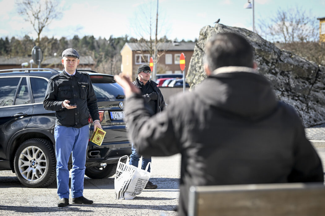 Rasmus Paludan, partiledare för det danska högerextrema partiet Stram kurs, med en koran i handen, på plats i Stockholmsförorten Rinkeby på långfredagen.