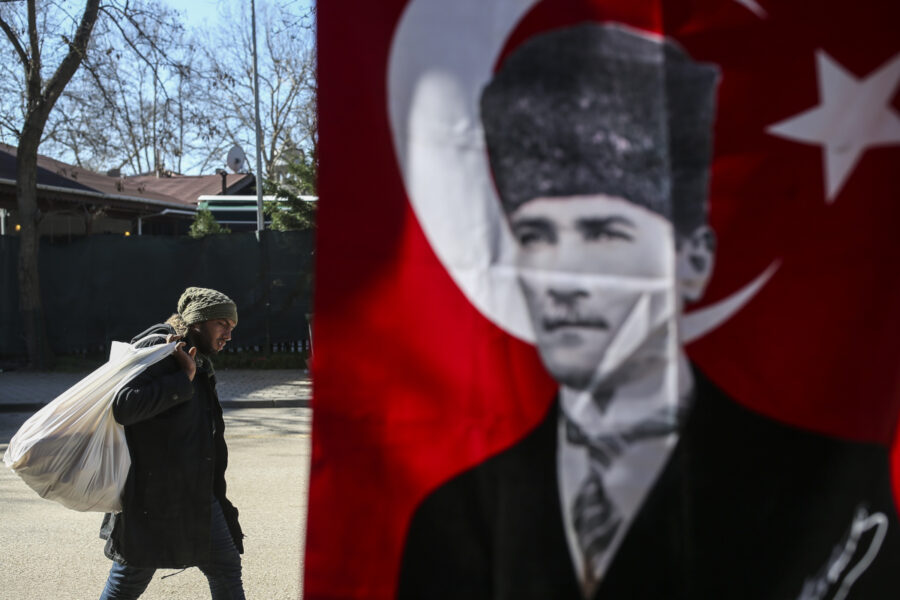 Migrant passerar bild på moderna Turkiets grundare Kemal Atatürk i Edirneregionen, nära Grekland.