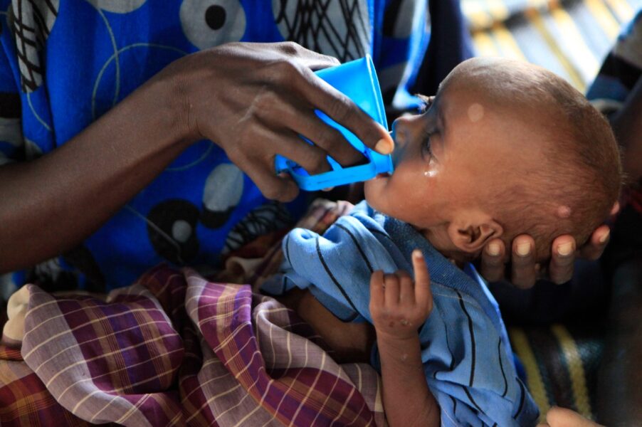 En mor ger vatten till sin hungrande bebis i östra Kenya.