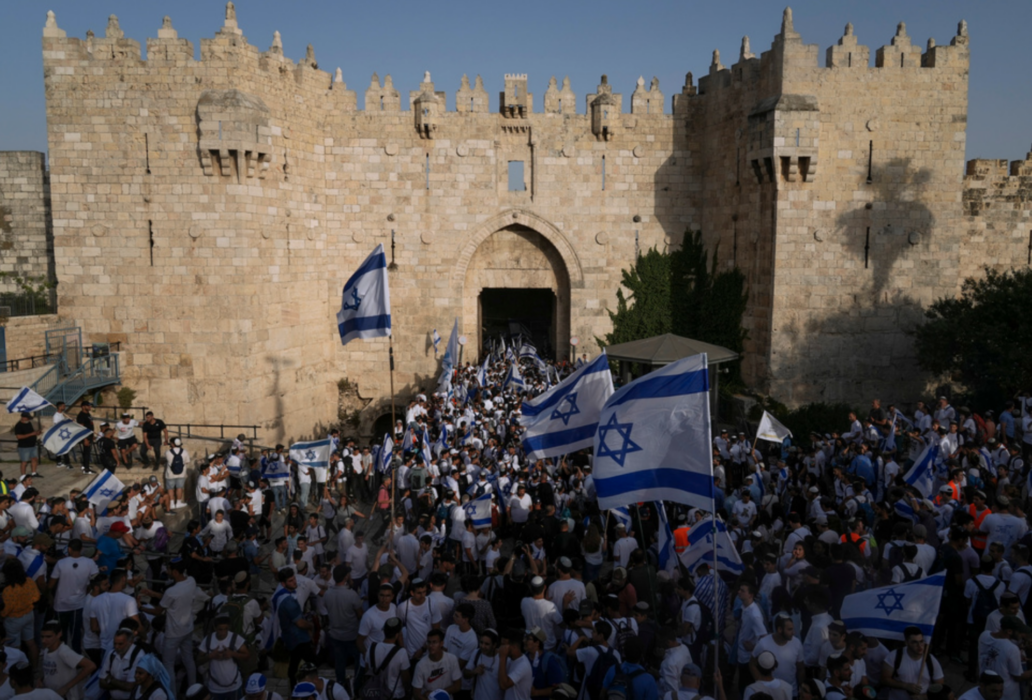 Israeler med flaggor utanför Damaskusporten i Jerusalem under söndagen.