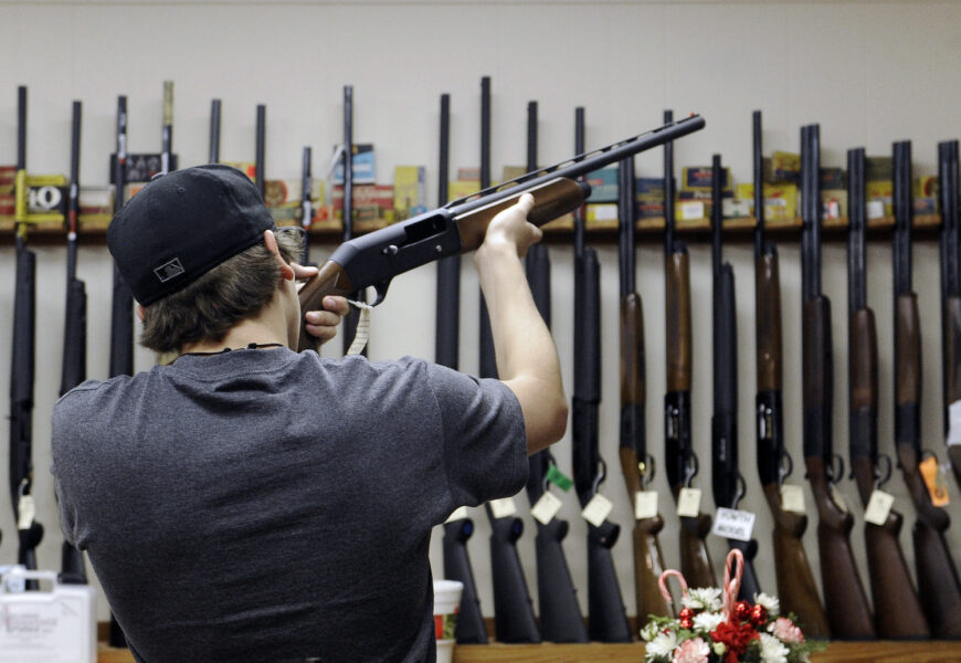 En man känner på ett hagelgevär i en vapenbutik i Texas.