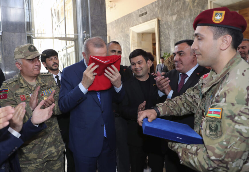 Turkiets president Erdogan kysser en turkisk flagga som erbjudits honom av soldater.