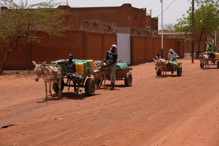 Kvinnor bär vatten i Djibo, Burkina Faso den 26 maj 2022.