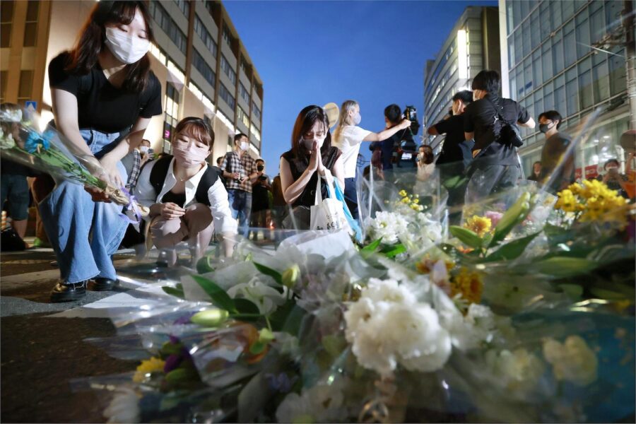 Människor samlas för att lägga ner blommor och be vid platsen där Japans tidigare premiärminister sköts under ett kampanjtal.