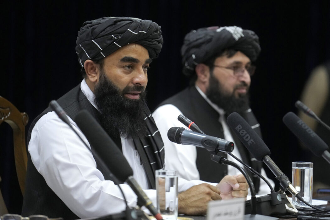 Zabiullah Mujahid (vänster), talesperson för talibanernas regering i Afghanistan, under en presskonferens i torsdags, då massmötet inleddes.