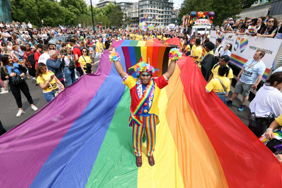 Londonbon Mohammed Nazir dansar på en jättelik regnbågsflagga under lördagens prideparad i den brittiska huvudstaden – som i år markerar att det är 50 år sedan priderörelsen drog i gång i staden.